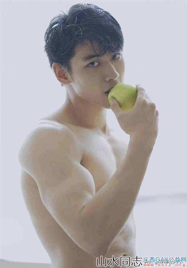 长相清秀笑容甜美的肌肉帅哥，手里拿着一只青苹果，正准备吃呢！